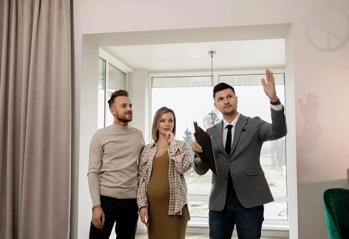 Paar bei einer sachlichen Besichtigung mit einem Immobilienberater